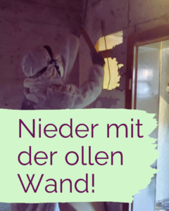 Eine Person reißt mit einem Hammer ein Loch in eine Wand.